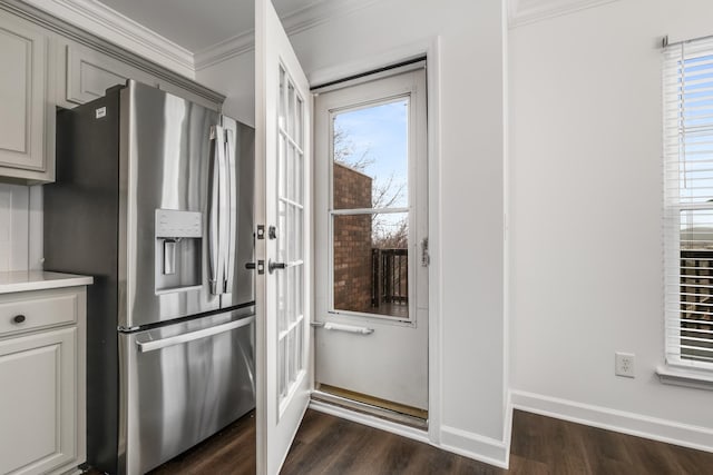 kitchen featuring dark wood-style floors, ornamental molding, a wealth of natural light, and stainless steel refrigerator with ice dispenser
