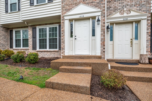 view of exterior entry featuring brick siding