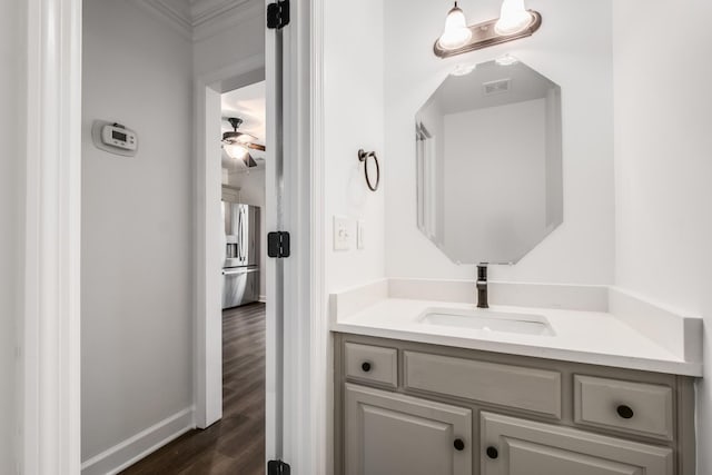 bathroom featuring a ceiling fan, baseboards, visible vents, vanity, and wood finished floors