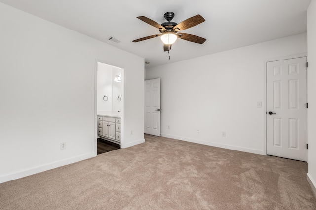 unfurnished bedroom featuring carpet, a ceiling fan, visible vents, baseboards, and ensuite bath