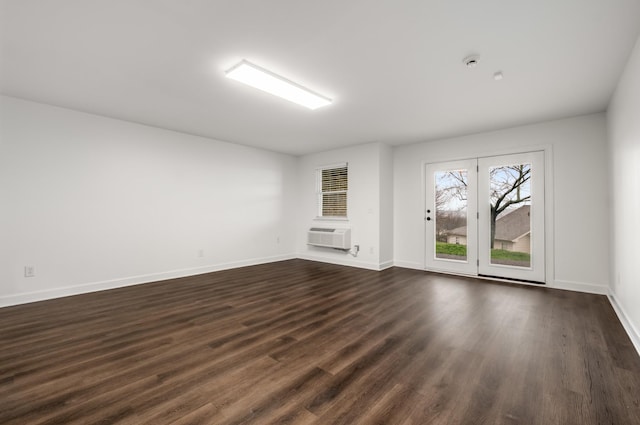 unfurnished room featuring a wall mounted AC, baseboards, and dark wood finished floors