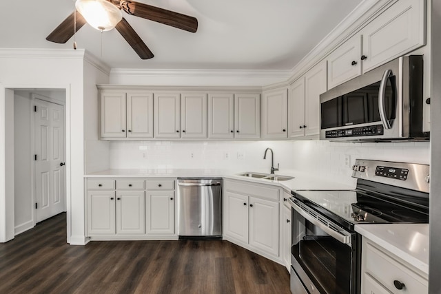 kitchen with a sink, decorative backsplash, light countertops, appliances with stainless steel finishes, and dark wood-style floors