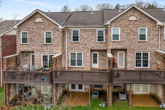 rear view of property with cooling unit, brick siding, and a deck