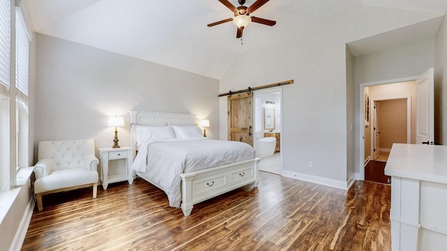 bedroom with ensuite bath, wood finished floors, a barn door, and high vaulted ceiling