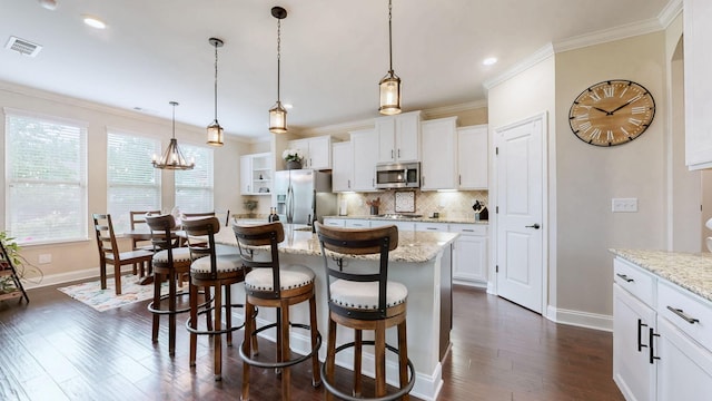 kitchen featuring ornamental molding, stainless steel appliances, baseboards, and visible vents