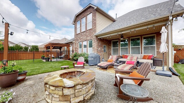 rear view of property with a ceiling fan, brick siding, an outdoor living space with a fire pit, roof with shingles, and a fenced backyard