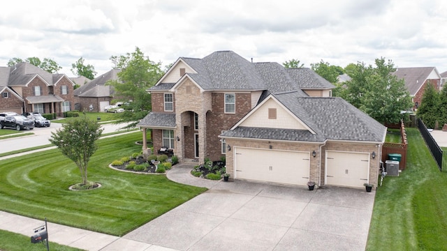 traditional-style house with concrete driveway, brick siding, a front yard, and a garage