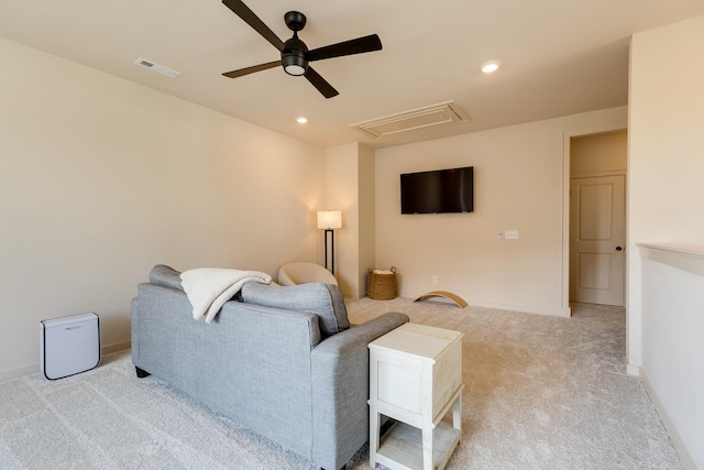 living room featuring attic access, visible vents, ceiling fan, light carpet, and baseboards
