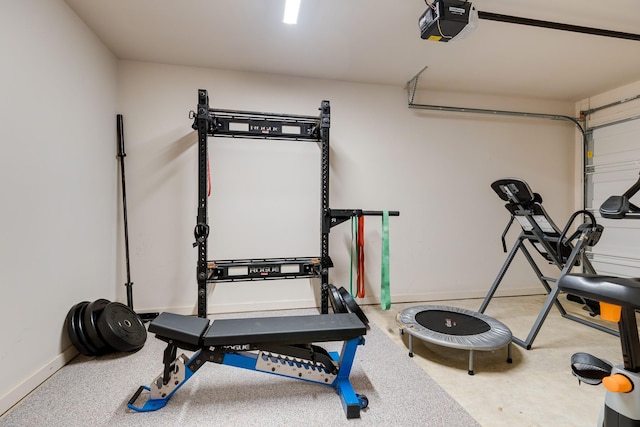 exercise room with baseboards and a garage