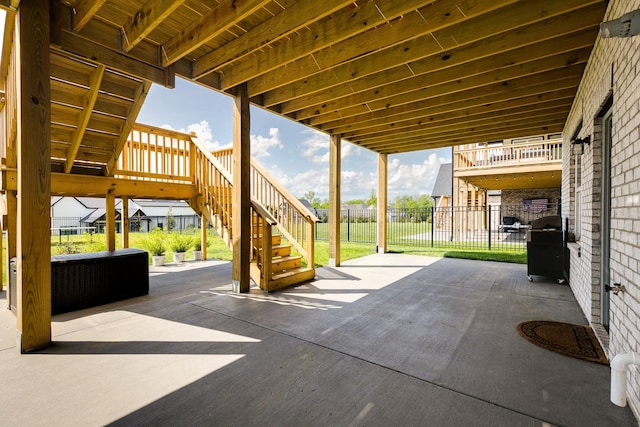 view of patio featuring a grill, stairs, and fence