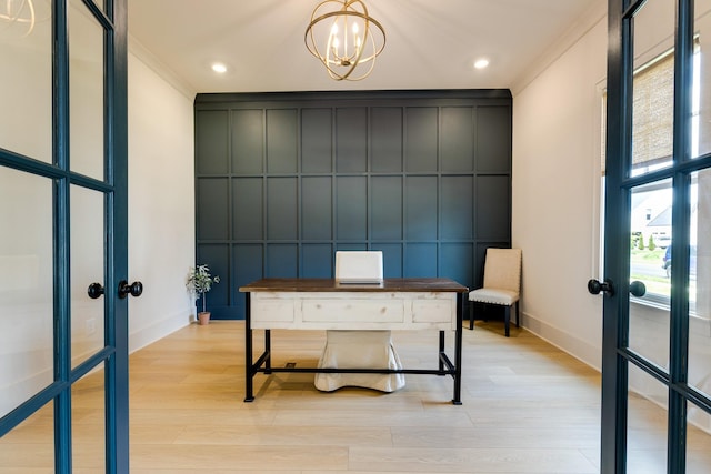 unfurnished office with crown molding, a decorative wall, french doors, and light wood-type flooring