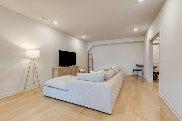 living area with light wood-style floors, visible vents, baseboards, and recessed lighting