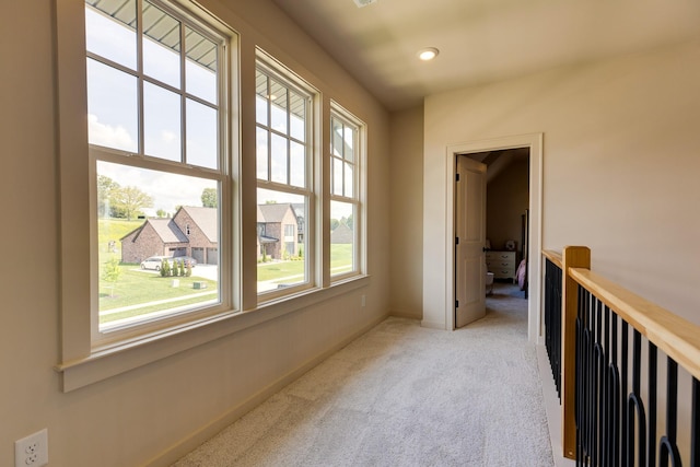 corridor with carpet floors, baseboards, a healthy amount of sunlight, and recessed lighting
