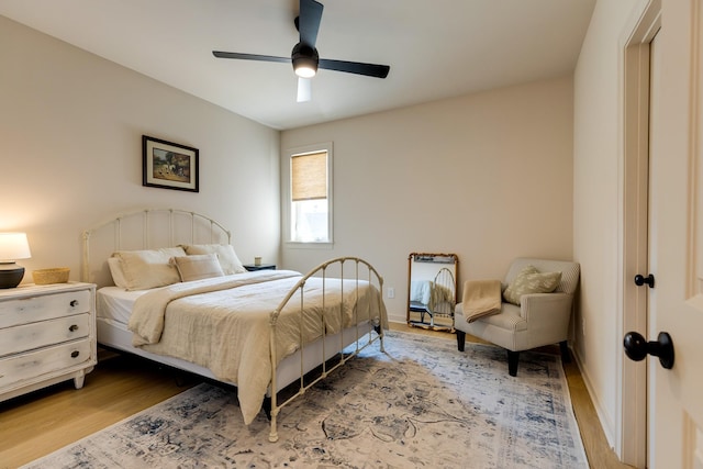 bedroom featuring baseboards, a ceiling fan, and wood finished floors