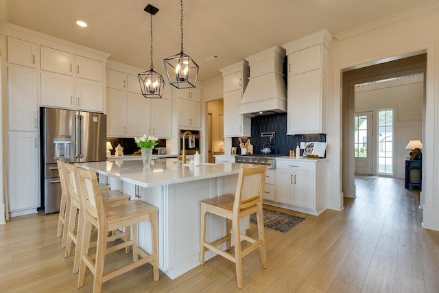 kitchen with recessed lighting, custom range hood, white cabinetry, decorative backsplash, and stainless steel appliances