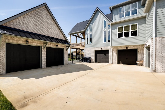 view of home's exterior featuring concrete driveway, brick siding, and a garage