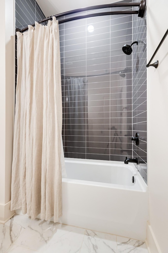 bathroom featuring shower / bathtub combination with curtain, marble finish floor, and baseboards