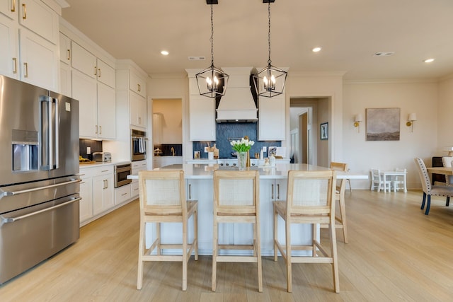 kitchen with an inviting chandelier, stainless steel appliances, light countertops, tasteful backsplash, and custom exhaust hood
