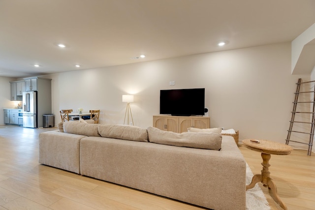 living room with light wood-style floors and recessed lighting