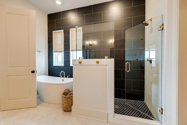 full bathroom featuring a stall shower, tile patterned flooring, tile walls, and a soaking tub