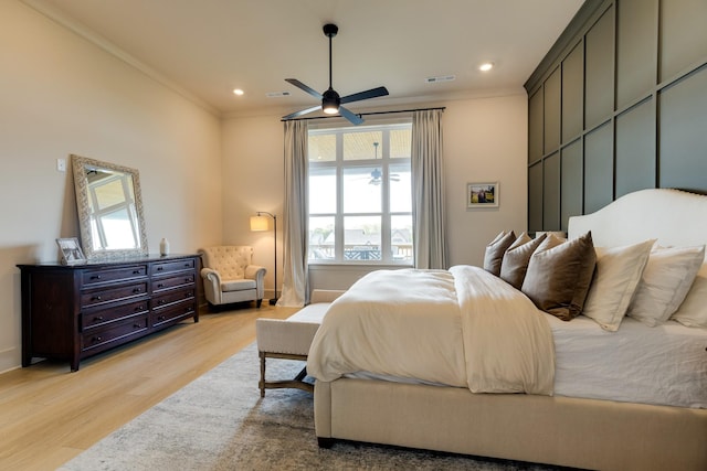 bedroom with light wood-style floors, crown molding, visible vents, and multiple windows