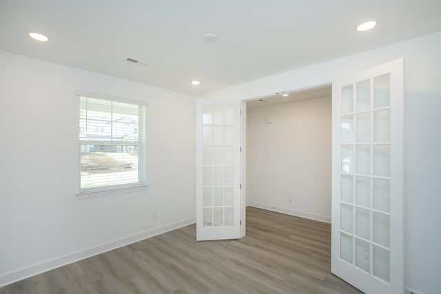 unfurnished room with wood finished floors, french doors, and recessed lighting
