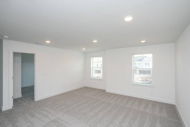 unfurnished room with baseboards, recessed lighting, and light colored carpet