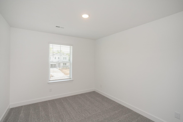 spare room with carpet, baseboards, visible vents, and recessed lighting