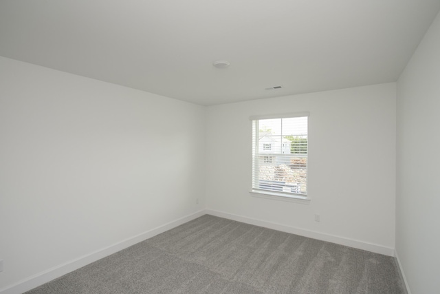 carpeted empty room with visible vents and baseboards
