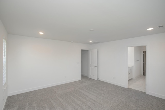 unfurnished bedroom with baseboards, visible vents, connected bathroom, and recessed lighting