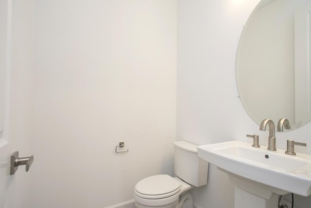 bathroom featuring a sink, toilet, and baseboards