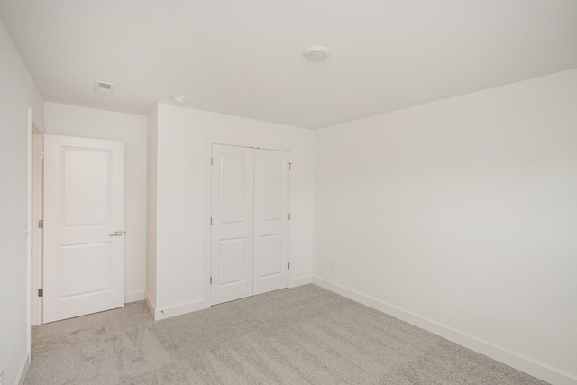 unfurnished bedroom with carpet flooring, a closet, visible vents, and baseboards