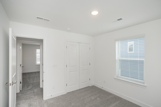 unfurnished bedroom with baseboards, carpet flooring, and visible vents