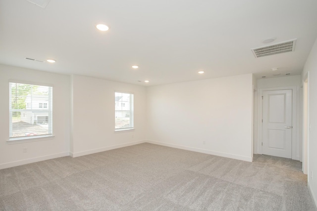 spare room with baseboards, recessed lighting, visible vents, and light colored carpet