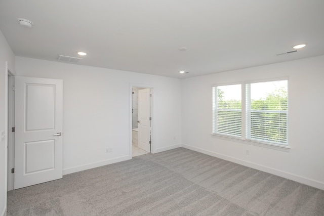 carpeted empty room featuring baseboards, recessed lighting, and visible vents