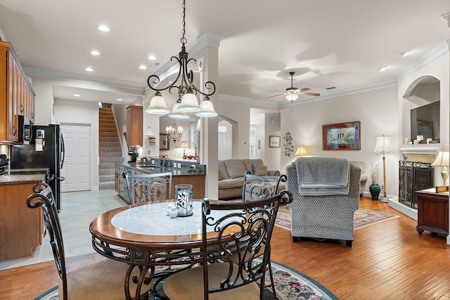 1230 Chickadee Cir, Hermitage, TN 37076 - dining space featuring stairs, ornamental molding, light wood finished floors, and ceiling fan with notable chandelier