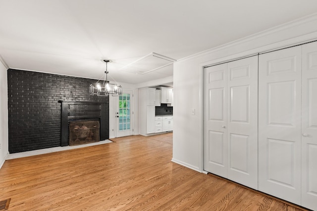 3103 Lakeland Dr, Nashville, TN 37214 - unfurnished living room featuring ornamental molding, light wood finished floors, an inviting chandelier, visible vents, and a brick fireplace