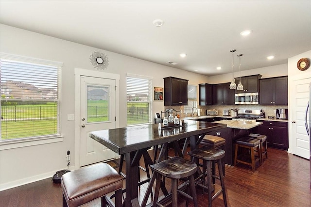 3157 Rift Ln, Murfreesboro, TN 37130 - kitchen featuring stainless steel appliances, dark wood-style floors, dark brown cabinets, backsplash, and a breakfast bar area