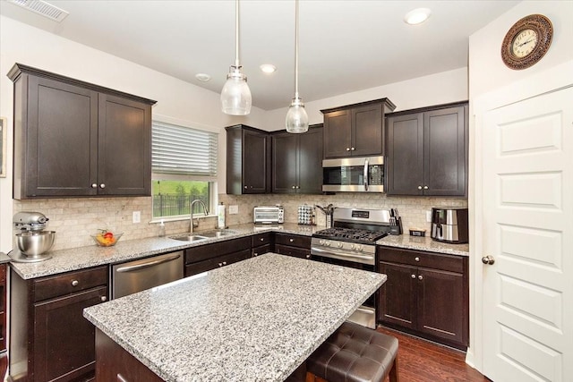 3157 Rift Ln, Murfreesboro, TN 37130 - kitchen with stainless steel appliances, a sink, light stone countertops, backsplash, and a center island