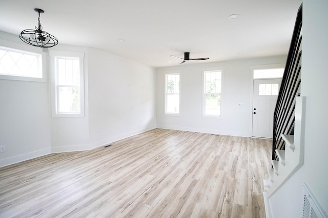 105 Shephard St N, Winchester, TN 37398 - unfurnished living room with baseboards, light wood finished floors, visible vents, ceiling fan with notable chandelier, and stairway