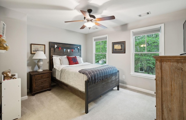 bedroom featuring light colored carpet, baseboards, ceiling fan, and visible vents