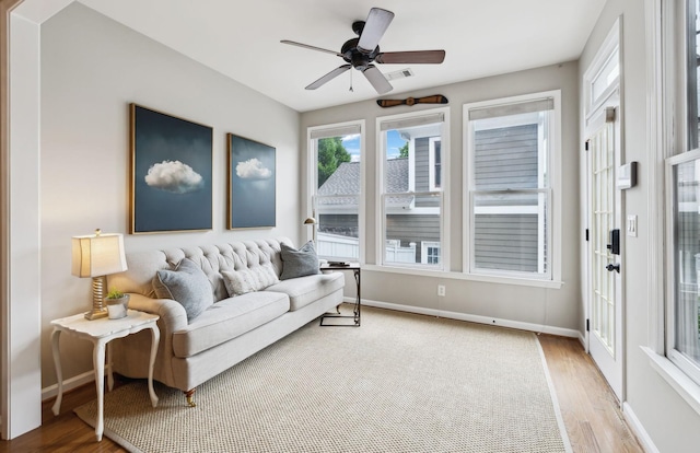 living area with a ceiling fan, baseboards, light wood-type flooring, and visible vents