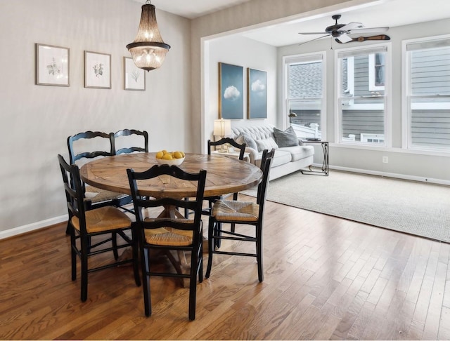 dining space featuring baseboards, ceiling fan, and wood finished floors