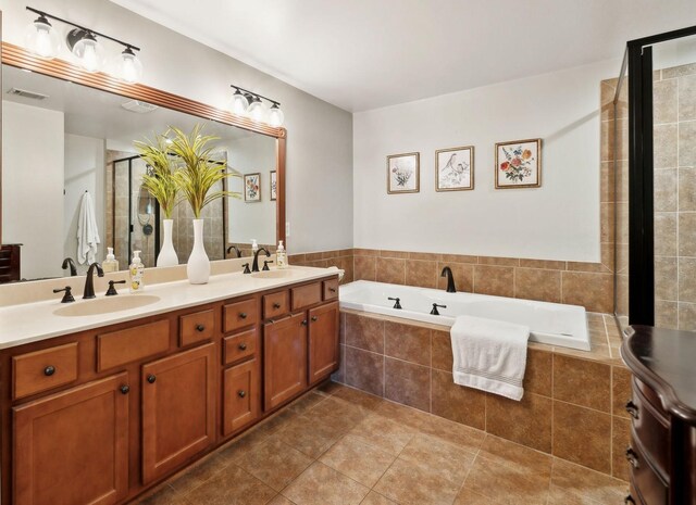 full bath featuring double vanity, a garden tub, visible vents, and a sink