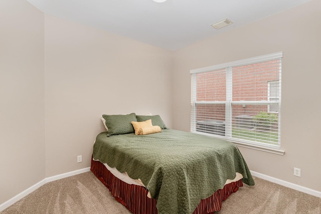 bedroom with baseboards, visible vents, and light colored carpet