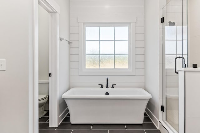 full bathroom featuring a stall shower, toilet, baseboards, and tile patterned floors