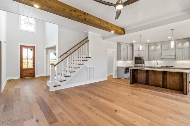 kitchen featuring gray cabinetry, light countertops, baseboards, and a wealth of natural light