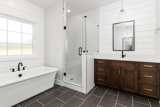 full bathroom featuring a stall shower, vanity, and a freestanding bath