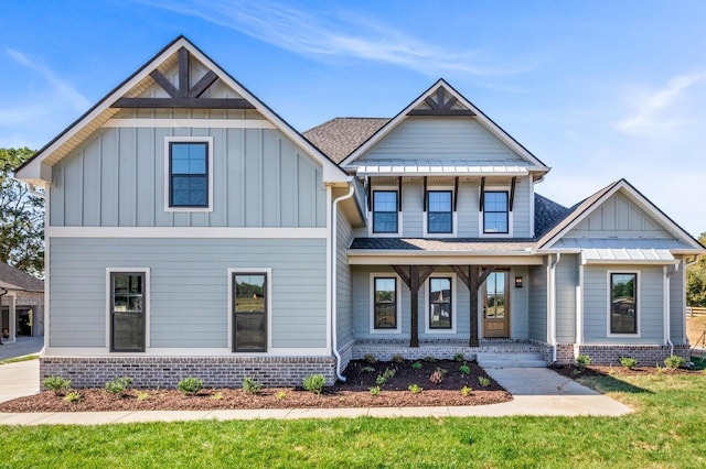 craftsman-style home with a shingled roof, board and batten siding, a porch, and a front yard