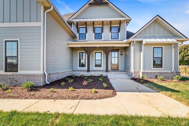 view of front of house featuring board and batten siding, a porch, and brick siding